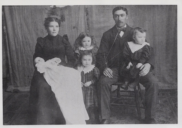 Amanda Beauvais (1876-1979 [sic]) et son époux Joseph-Hilaire Mulaire (1871-1930), avec leurs enfants : Émery sur les genoux de sa mère, Imelda et Évélina, et Jean-Baptiste. 1900. Archives provinciales du Manitoba.
